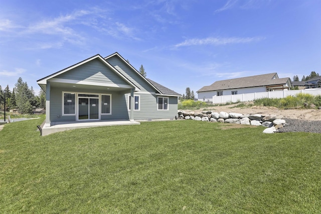 rear view of property with a patio area, a lawn, and fence