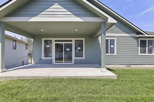 back of house featuring crawl space, a patio area, and a lawn