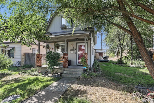 view of front of home featuring covered porch, board and batten siding, and a front yard