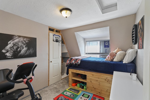 carpeted bedroom featuring a textured ceiling and attic access