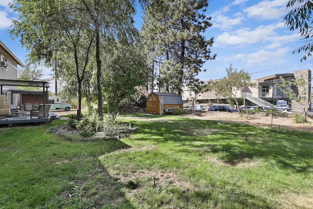 view of yard featuring a shed, a deck, and an outdoor structure