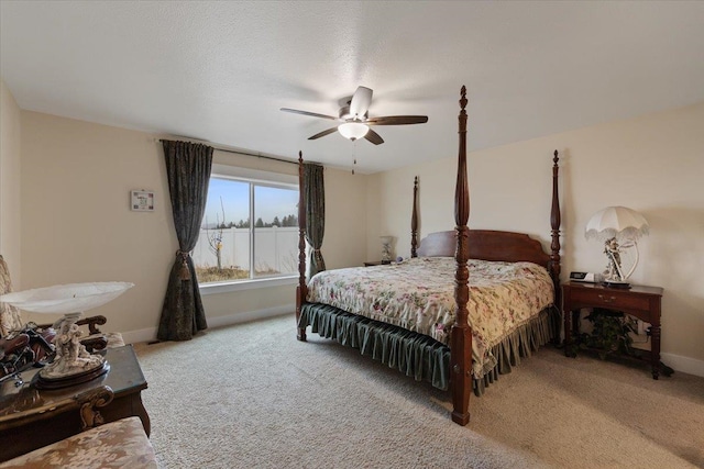 carpeted bedroom featuring ceiling fan, baseboards, and a textured ceiling