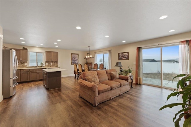 living area with dark wood-style floors, a chandelier, and recessed lighting