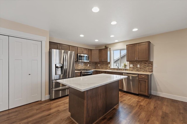 kitchen with dark wood-style floors, appliances with stainless steel finishes, backsplash, and a sink