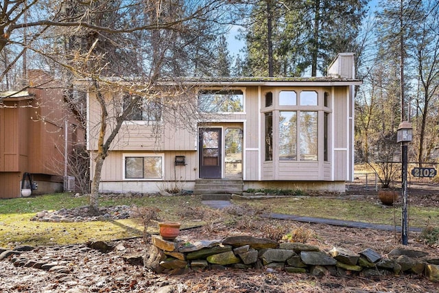 view of front of property featuring entry steps and a chimney