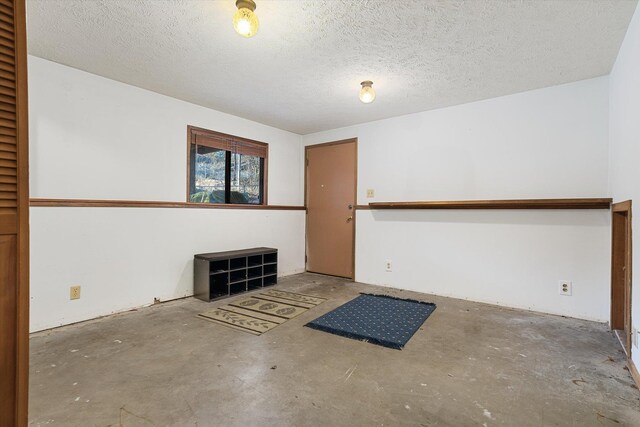 spare room featuring concrete floors and a textured ceiling