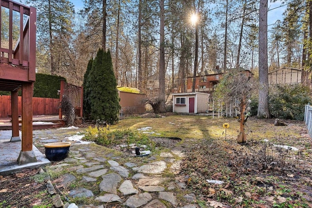 view of yard with an outbuilding, a shed, and fence