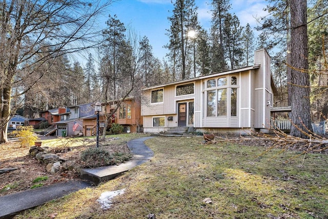 raised ranch featuring a chimney and a wooden deck