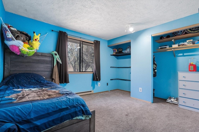 carpeted bedroom featuring a baseboard heating unit, a textured ceiling, and baseboards