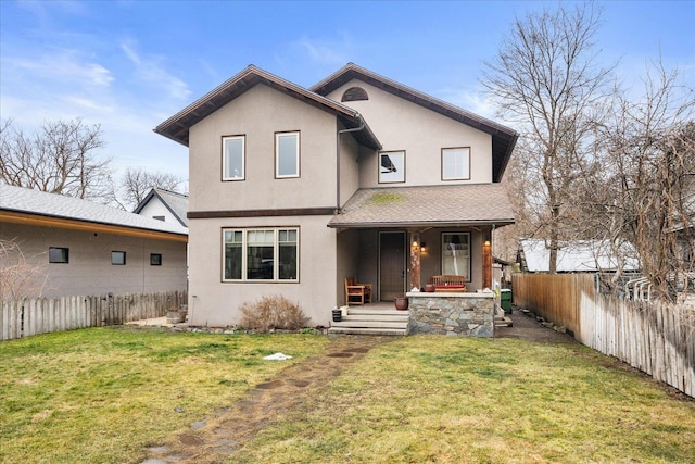 back of house featuring covered porch, a lawn, and stucco siding