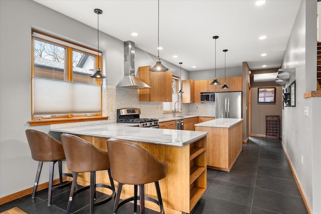 kitchen featuring a peninsula, a sink, appliances with stainless steel finishes, wall chimney exhaust hood, and tasteful backsplash