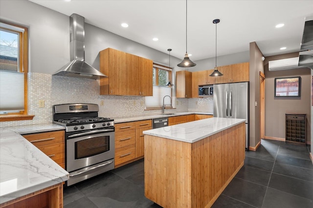 kitchen with brown cabinetry, a wall mounted air conditioner, stainless steel appliances, wall chimney range hood, and a sink