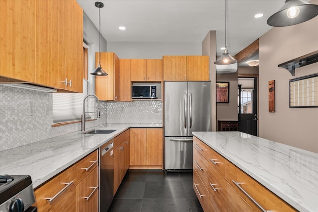 kitchen with light stone countertops, a sink, appliances with stainless steel finishes, decorative backsplash, and brown cabinets