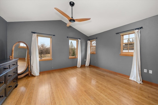 unfurnished bedroom featuring light wood-type flooring, multiple windows, vaulted ceiling, and a ceiling fan