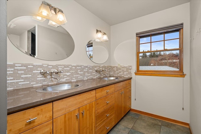 bathroom with a sink, backsplash, baseboards, and double vanity