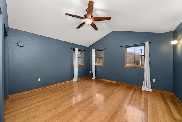 unfurnished bedroom with lofted ceiling, hardwood / wood-style floors, a ceiling fan, and baseboards