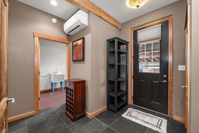 entrance foyer with dark tile patterned floors, baseboards, and a wall mounted AC