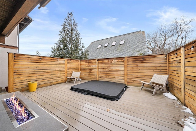 deck with an outdoor fire pit and a fenced backyard