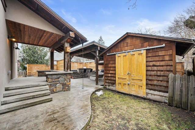 view of outdoor structure featuring fence and an outdoor structure