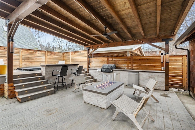 view of patio / terrace with an outdoor fire pit, a ceiling fan, a fenced backyard, outdoor dry bar, and a grill