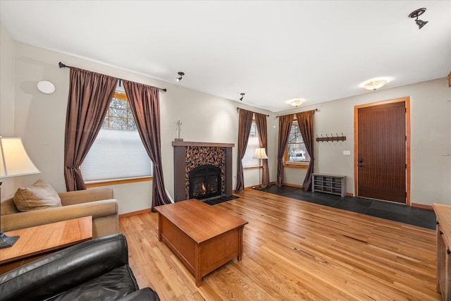 living room featuring baseboards, a fireplace, and light wood-style floors