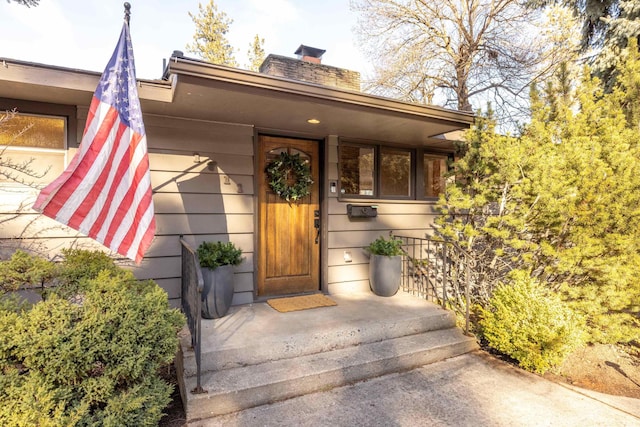 view of exterior entry with a chimney