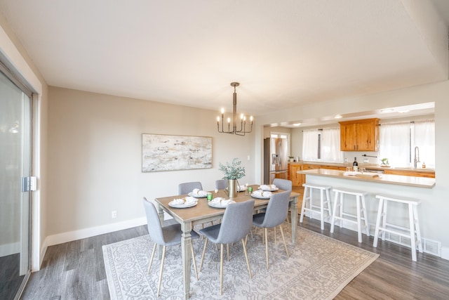 dining area with baseboards, dark wood finished floors, and a chandelier