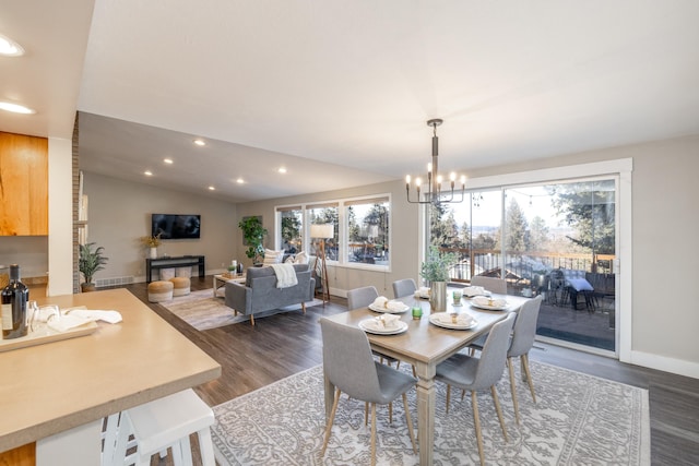 dining room featuring vaulted ceiling, dark wood-type flooring, recessed lighting, and a notable chandelier