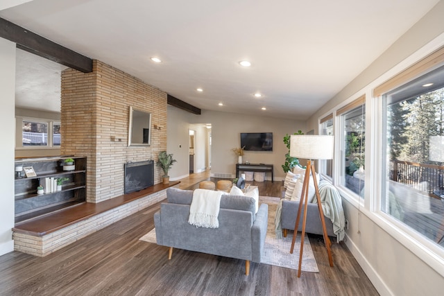 living room with lofted ceiling with beams, plenty of natural light, a fireplace, and wood finished floors