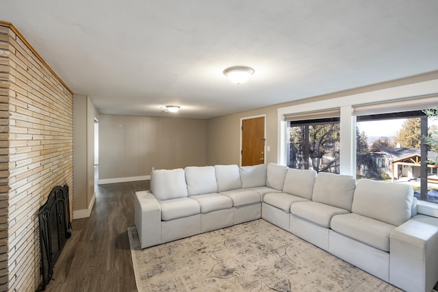 living area with a fireplace, baseboards, and dark wood-style flooring