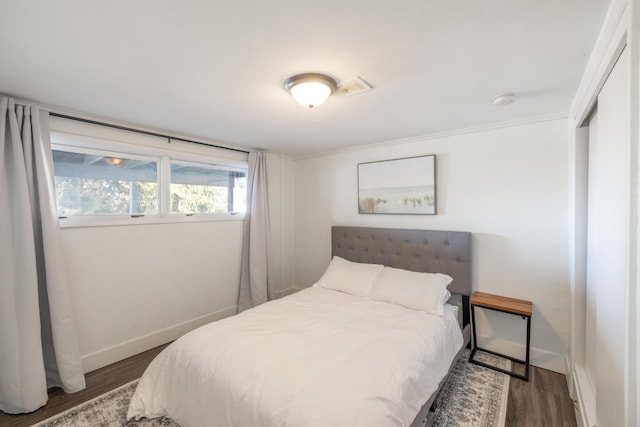 bedroom with baseboards and wood finished floors