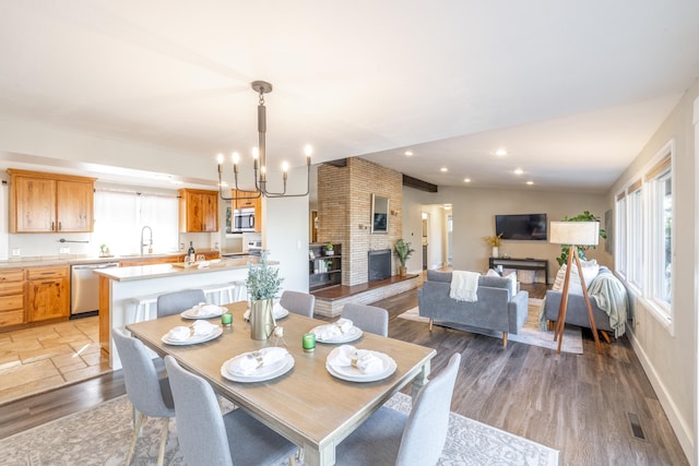 dining area featuring lofted ceiling, a chandelier, recessed lighting, a large fireplace, and visible vents