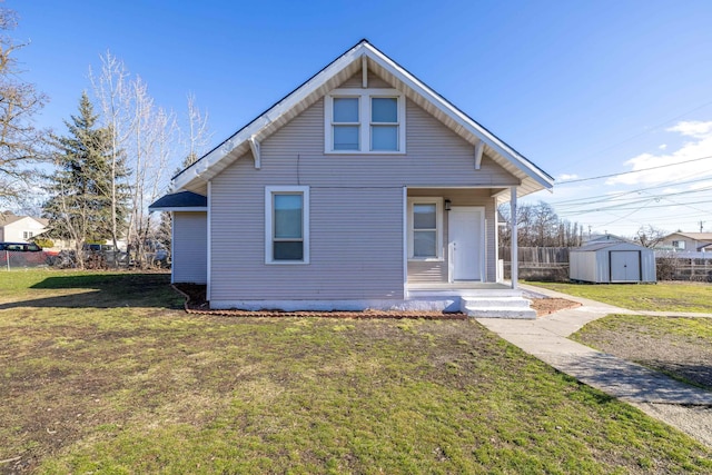 view of front of home featuring an outbuilding, a storage unit, a front yard, and fence