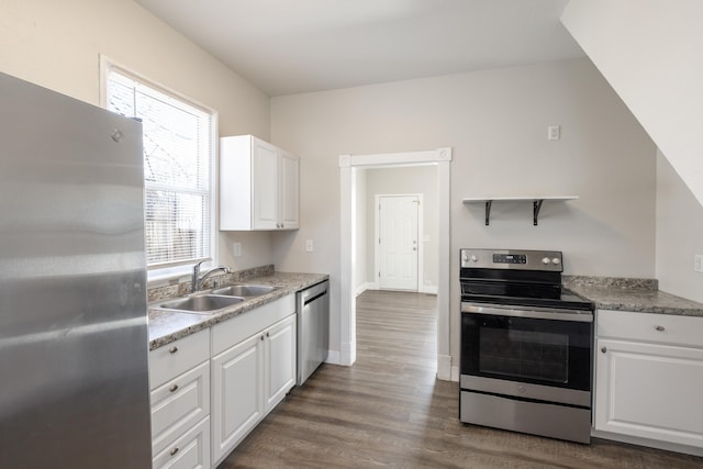 kitchen featuring stainless steel appliances, dark wood-type flooring, a sink, and white cabinets