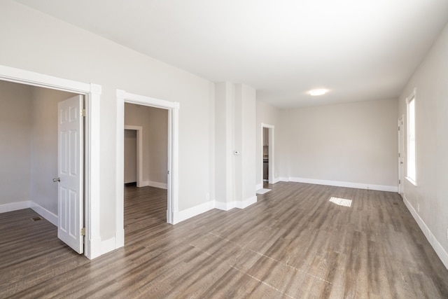 unfurnished room featuring baseboards and wood finished floors