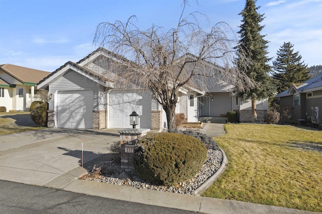 ranch-style home with an attached garage, brick siding, concrete driveway, and a front yard