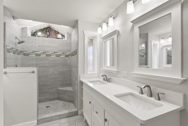 full bath with double vanity, walk in shower, and a sink
