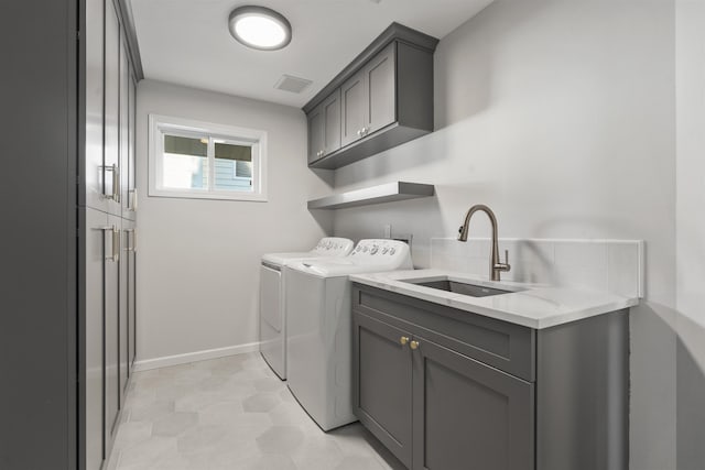 laundry area with cabinet space, baseboards, visible vents, independent washer and dryer, and a sink