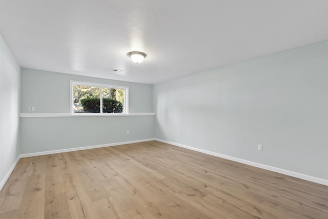 empty room with baseboards and wood finished floors