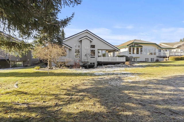 rear view of property with a deck and a lawn