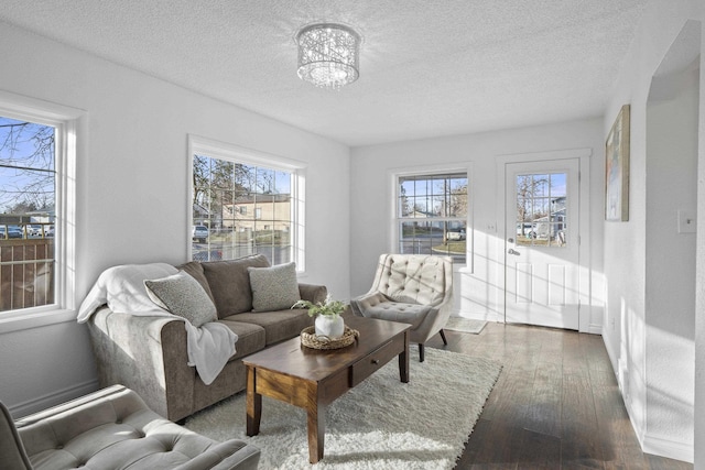 living area with hardwood / wood-style flooring, a notable chandelier, and a textured ceiling