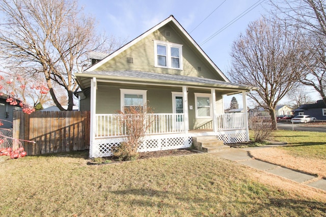 bungalow-style house featuring a front yard, covered porch, roof with shingles, and fence