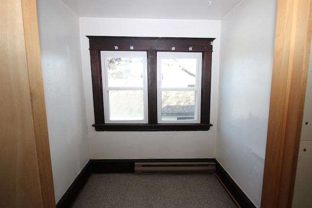 carpeted empty room with baseboards and a baseboard radiator