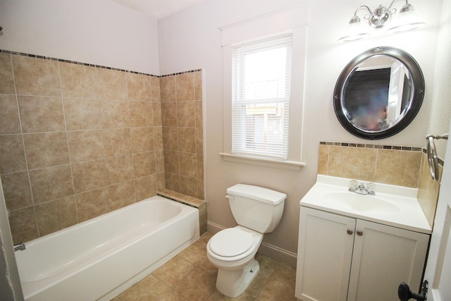 bathroom featuring tile patterned floors, toilet, baseboards, shower / washtub combination, and vanity