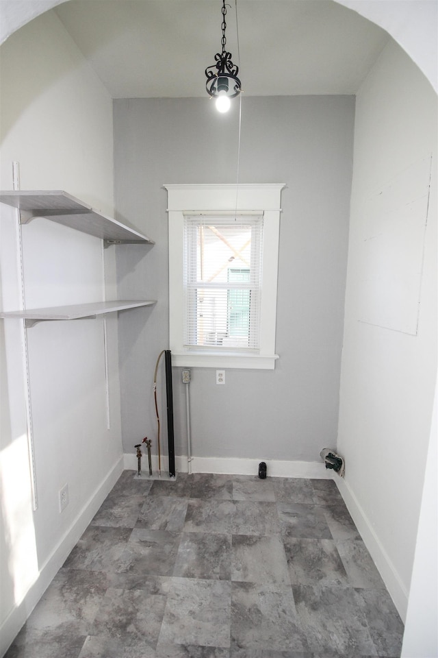 clothes washing area with baseboards and laundry area