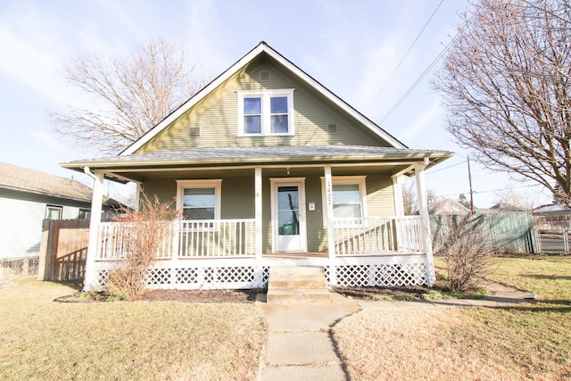 bungalow-style house with a porch, a front yard, and fence