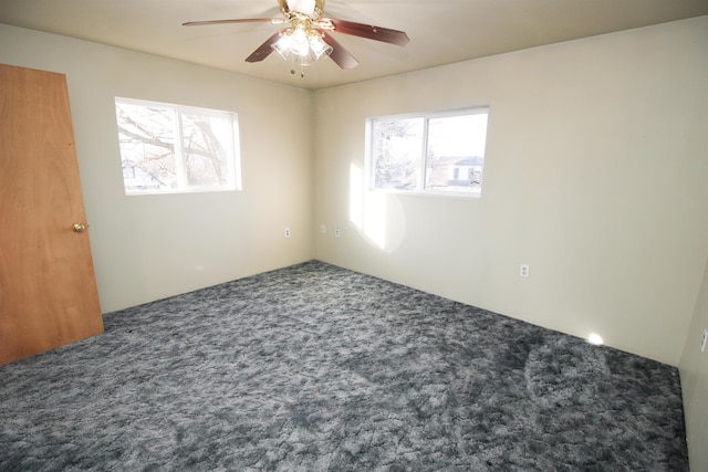 carpeted empty room with a ceiling fan