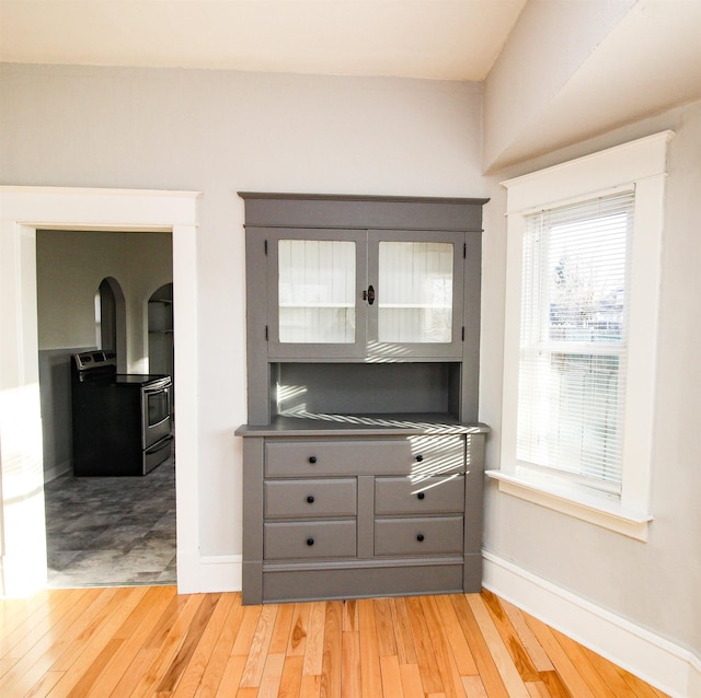 room details with baseboards, wood finished floors, and electric stove