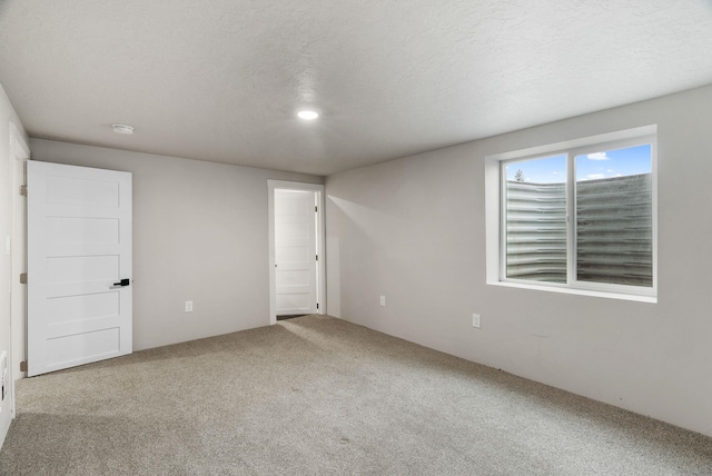 carpeted spare room with a textured ceiling