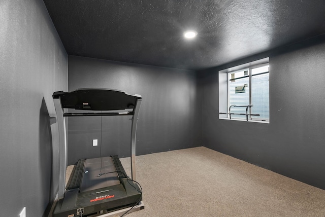 workout area with a textured ceiling and carpet